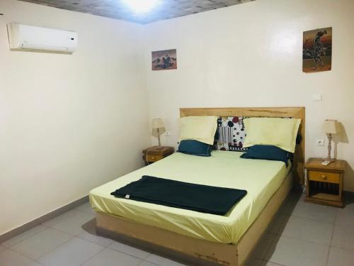 a bedroom with a bed and two night stands at Lodge Kabacoto in Nioro du Rip