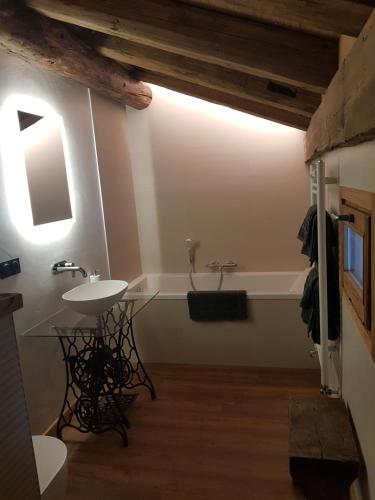 een badkamer met een wastafel en een bad bij Aux fermes de la Croix, chambres, petits-déjeuners, diners in Hauteluce