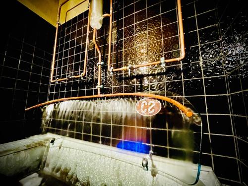 a shower with water coming out of a wall with a skateboard at HARABURDI® Recyclart Hotel in Kostelec nad Orlicí
