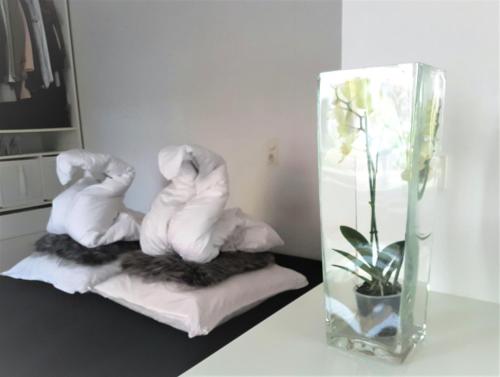 two towel sculptures sitting on towels next to a vase at Get-your-flat - Tiny Flat in Gründerzeithaus, super sweet, Kreuzviertel - 50 m2 EG Haustier auf Anfrage in Dortmund