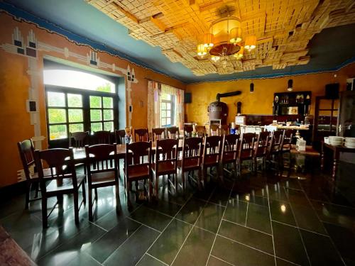 a dining room with a long table and chairs at HARABURDI® Recyclart Hotel in Kostelec nad Orlicí