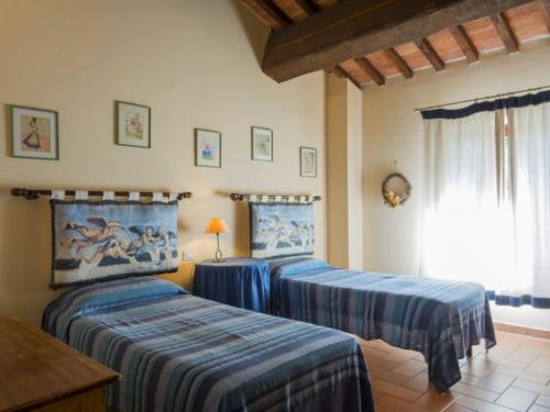 a bedroom with two beds and a table and a window at Tenuta La Casetta in Casciana Terme