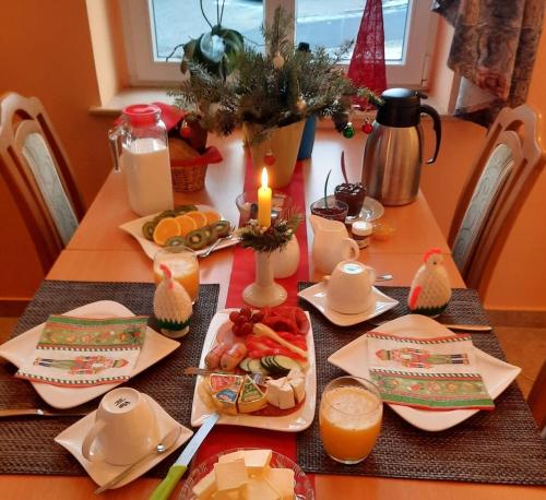a table topped with plates of food and a candle at Pension Schöne in Großröhrsdorf