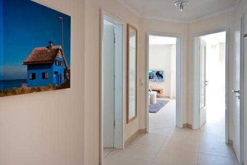 un pasillo con una pintura de una casa en la pared en Ostsee Lodges mit Wellnessbereich, en Timmendorfer Strand