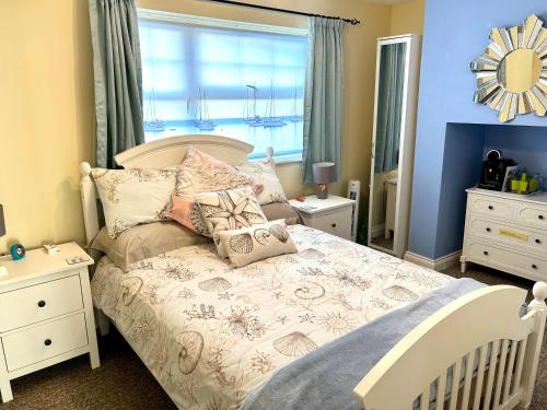 a bedroom with a white bed with pillows and a window at BAKERY CENTRAL in Cromer
