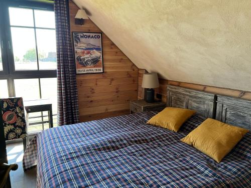 1 dormitorio con 1 cama con manta azul y almohadas amarillas en Cuda Wianki Mazury, 
