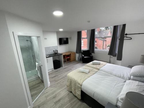 a bedroom with a large bed and a bathroom at ISUITES in Newcastle under Lyme