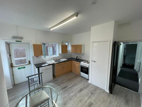 an empty kitchen with a table and a chair in it at ISUITES in Newcastle under Lyme