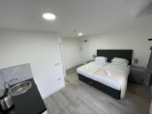 a bedroom with a bed and a sink in it at ISUITES in Newcastle under Lyme
