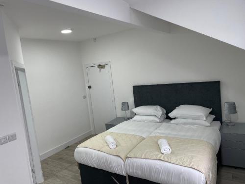 a bedroom with a large bed with two pillows on it at ISUITES in Newcastle under Lyme