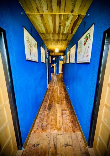 a hallway with blue walls and a wooden floor at HARABURDI® Recyclart Hotel in Kostelec nad Orlicí