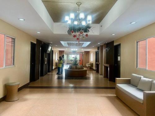 a lobby with a chandelier and a person standing in it at Condominium Suites at Chateau Elysee - Ritz in Manila