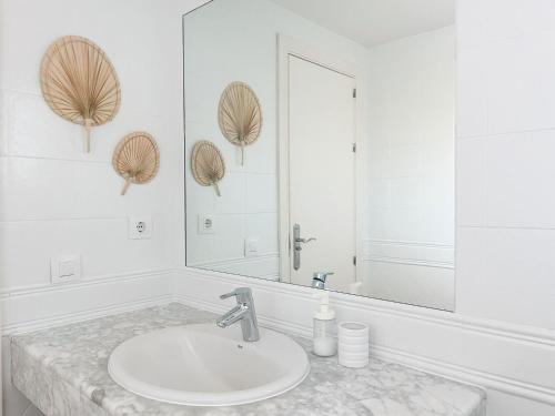 a white bathroom with a sink and a mirror at Casa Bezunia, Costa Calma in Costa Calma