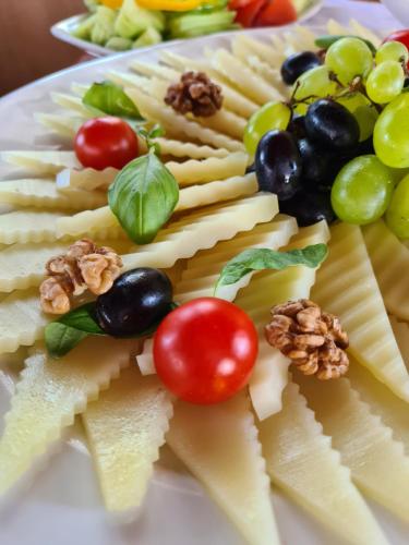 a plate topped with cheese and grapes and nuts at Mediterranean Village San Antonio in Biograd na Moru