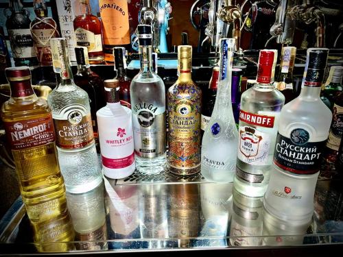 a group of bottles of alcohol sitting on a bar at HARABURDI® Recyclart Hotel in Kostelec nad Orlicí
