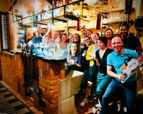 a group of people posing behind a bar at HARABURDI® Recyclart Hotel in Kostelec nad Orlicí