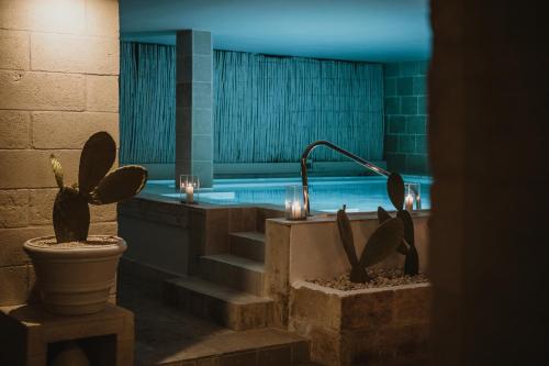 e bagno con vasca, servizi igienici e cactus. di Canne Bianche Lifestyle Hotel a Torre Canne