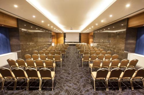 a conference room with a row of chairs and a screen at Elexus Hotel Resort & Spa & Casino in Kérynia