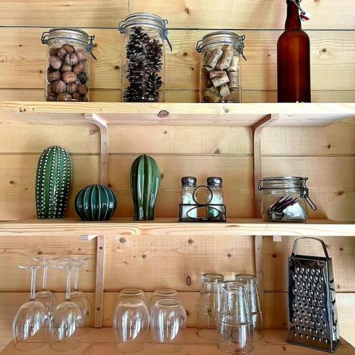 une étagère en bois avec des verres et d'autres articles sur celle-ci dans l'établissement Une pause là-haut!, à Grendelbruch