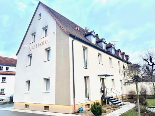 ein großes weißes Gebäude mit spitzem Dach in der Unterkunft Aparthotel Gartenstadt in Bamberg