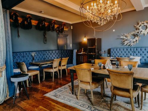 a dining room with tables and chairs and a chandelier at Verzon House in Ledbury