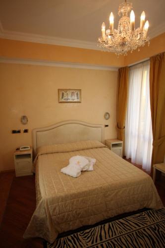 a bedroom with a bed with a towel on it at Hotel Vienna Ostenda e Ristorante il Danubio in Rimini