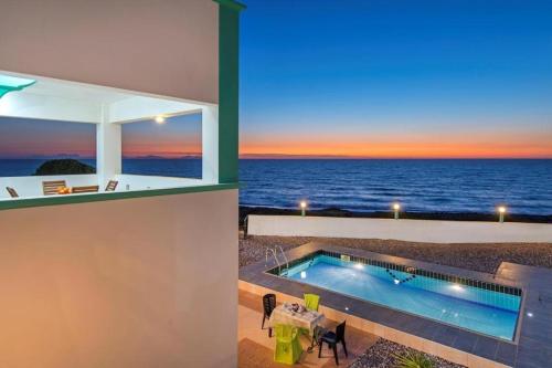 a house with a swimming pool and a view of the ocean at Pearl Villas Apolakkia - Beach Front Villas with Private Pool in Apolakkiá