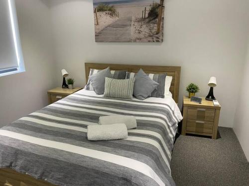 um quarto com uma cama grande e 2 mesas de cabeceira em Marina Point em Sandstone Point
