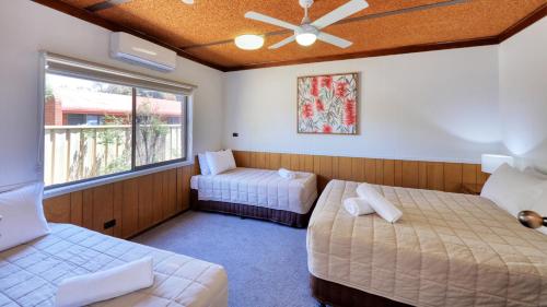 a room with two beds and a window at Motel Meneres in Corowa
