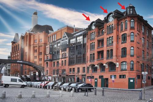 a large brick building with cars parked in front of it at LOFT-Panoramablick-HAFEN & ELBE! in Hamburg