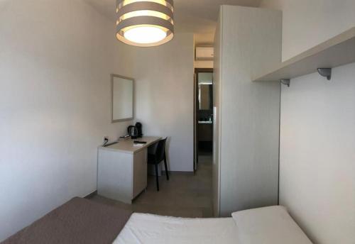 a room with a bed and a desk and a sink at SUPER APPARTAMENTO TERRAZZA PANORAMICA 3 CAMERE in Villasimius