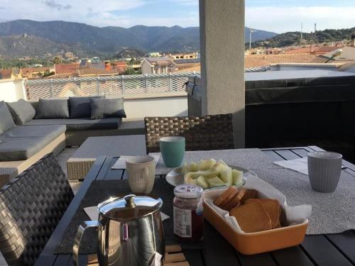 a table with a tray of food on a balcony at SUPER APPARTAMENTO TERRAZZA PANORAMICA 3 CAMERE in Villasimius