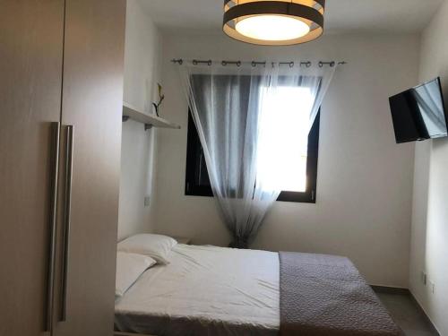 a bedroom with a bed and a window at SUPER APPARTAMENTO TERRAZZA PANORAMICA 3 CAMERE in Villasimius