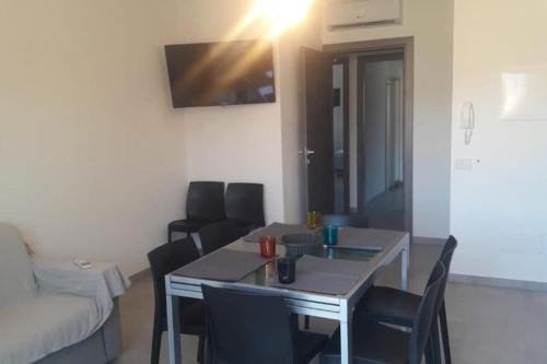 a living room with a table and chairs and a couch at SUPER APPARTAMENTO TERRAZZA PANORAMICA 3 CAMERE in Villasimius