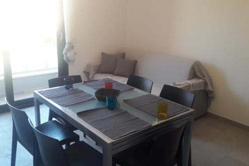 a table and chairs in a room with a couch at SUPER APPARTAMENTO TERRAZZA PANORAMICA 3 CAMERE in Villasimius