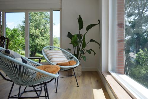 sala de estar con 2 sillas y ventana en Areitio etxea - casa con jardin, en Mallavia