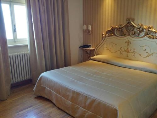 a bedroom with a bed with an ornate headboard at Villa Tuscolana in Frascati