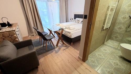 a living room with a couch and a bed and a table at Apartamenty Nowa Osada - by VillaOlimpijska2 in Wisła