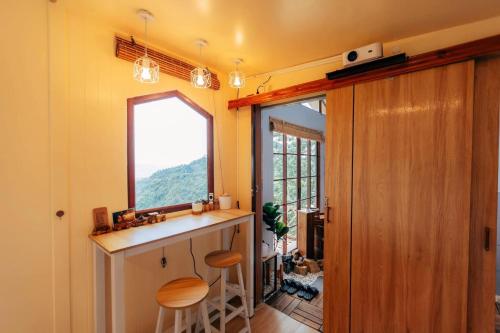 a kitchen with a counter and a window at At The Mountain Cottage, Tiny Home at Doichang with Hot tub Included Breakfast and Dinner in Ban Huai Khai