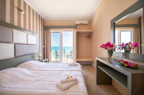 a hotel room with two beds with a view of the ocean at Aktypis Beachfront Studios in Laganas