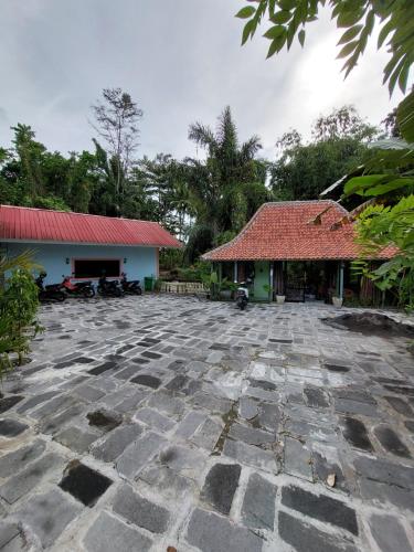 un cortile in pietra di fronte a un edificio con tetto rosso di Villa Kamar Tamu Selomartani a Sleman