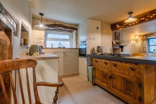 - une cuisine avec un comptoir et une cuisinière four supérieur dans l'établissement Cotswold Way Cottage, à Stroud