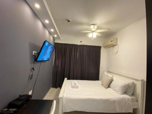 a bedroom with a bed and a flat screen tv at Rothschild 79 in Petaẖ Tiqwa