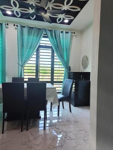 uma sala de jantar com uma mesa e cadeiras e uma ventoinha de tecto em Qs Family Homestay Pasir Mas em Pasir Mas