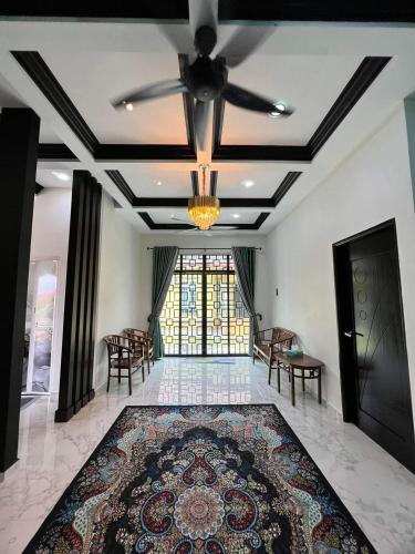 a living room with a ceiling fan and a rug at Qs Family Homestay Pasir Mas in Pasir Mas