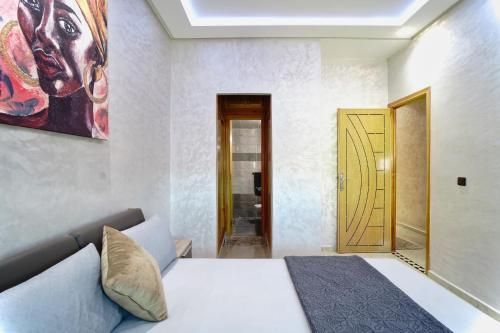um quarto com uma cama e um quadro na parede em Appartement moderne quartier calme em Fez