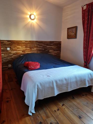 een slaapkamer met een bed met een rood kussen erop bij Petit gite de Provence in Mazan