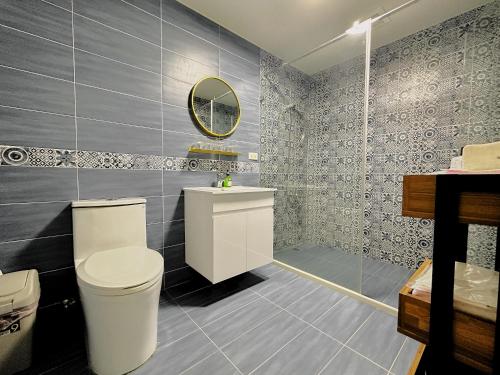 W łazience znajduje się toaleta, umywalka i lustro. w obiekcie 喜苑民宿 w Jinhu