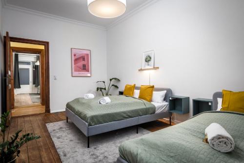 - une chambre avec 2 lits et des oreillers jaunes dans l'établissement Super Zentral super schöner Altbau in Moabit Rostockerstraße im Herzen von Berlin für bis zu 6 Personen, à Berlin
