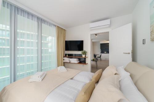 sala de estar blanca con sofá y TV en Sea Waves Apartament Resort & SPA 428B by Renters en Międzyzdroje